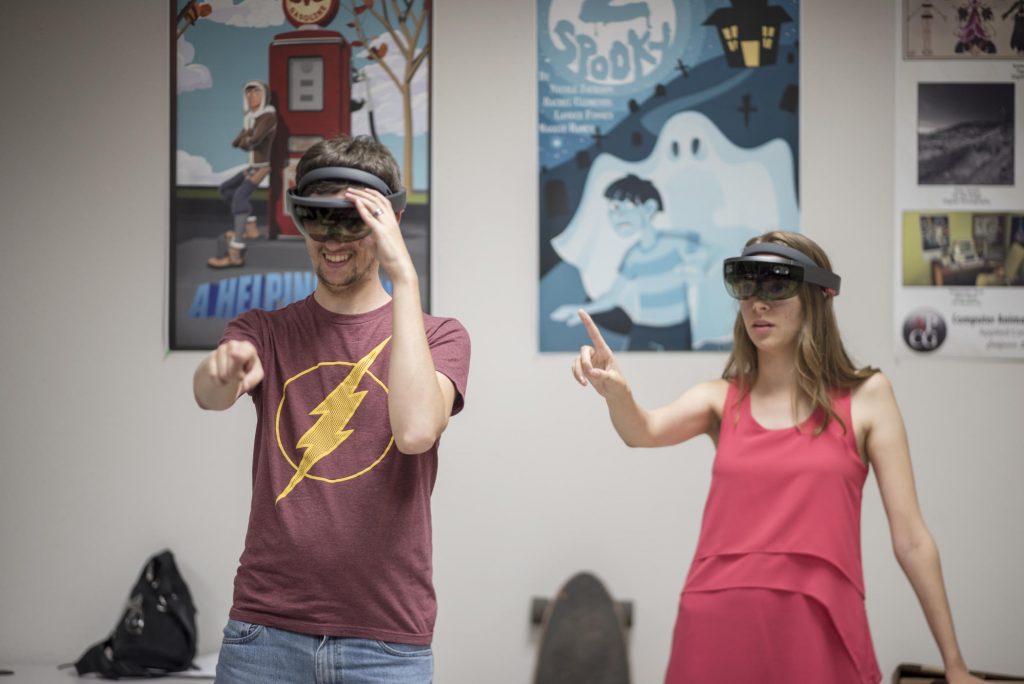Computer Animation and Game Development (CAGD) student  Tony Alessio (left) and Media Arts, Design and Technology (MADT) Sarah Rose Vaughn (right) wear a Microsoft HoloLens.