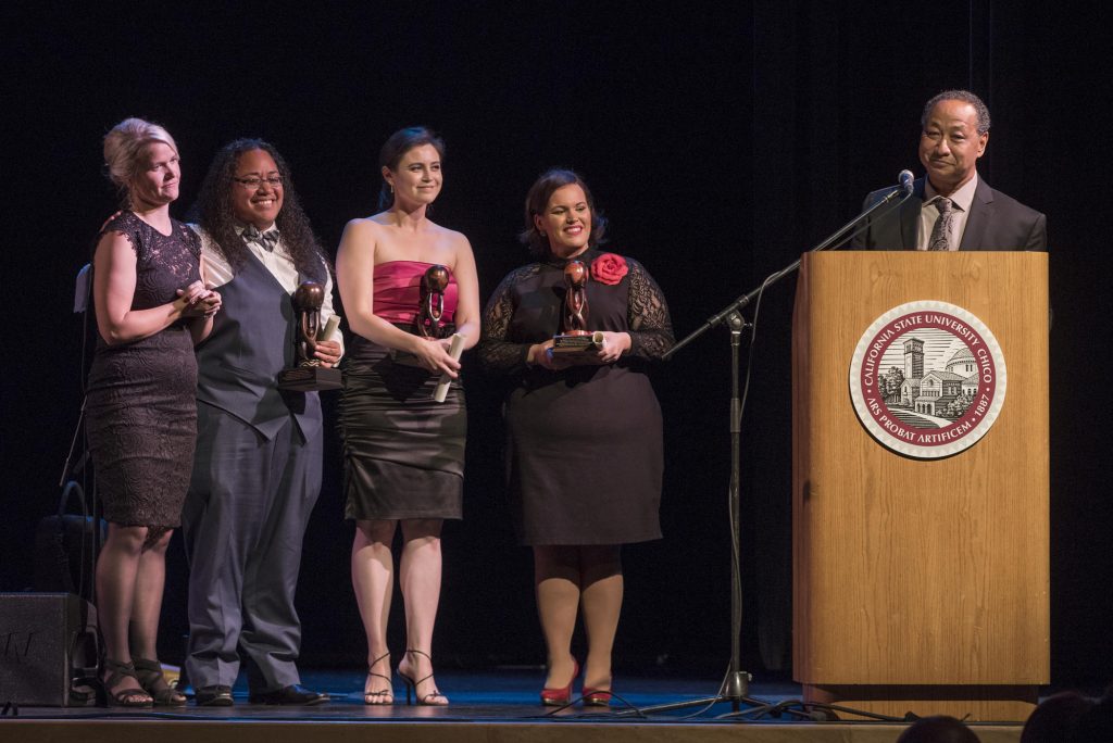 Katie Peterson, Krystle Tonga, Amy Hormann, and Erica Flores stand on stage at the CCLC's Open House and Gala to receive an advocate recognition from Carter.
