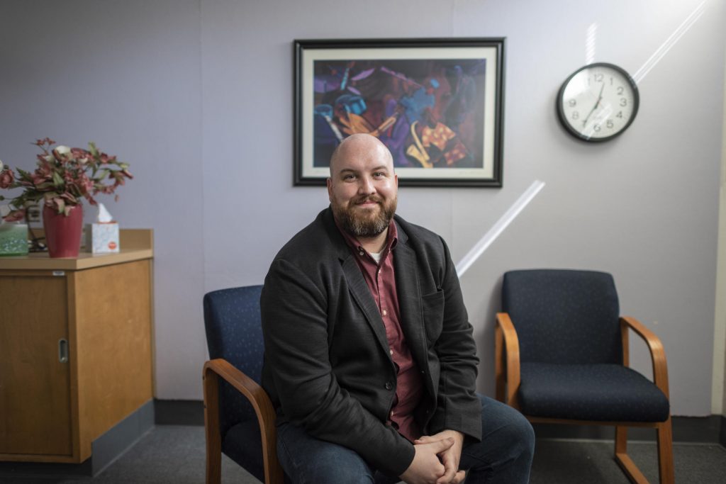 Kyle Horst sits with a pleasant smile in his office, ready to welcome therapy clients