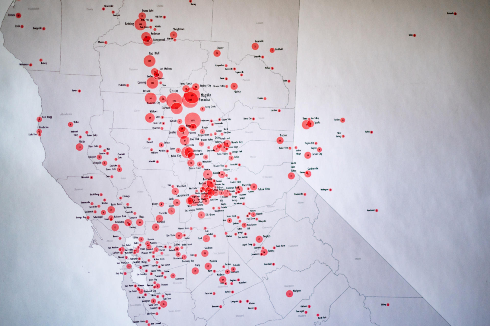 A California map with red circles of different sizes represent population sizes where people have moved to after the Camp Fire.