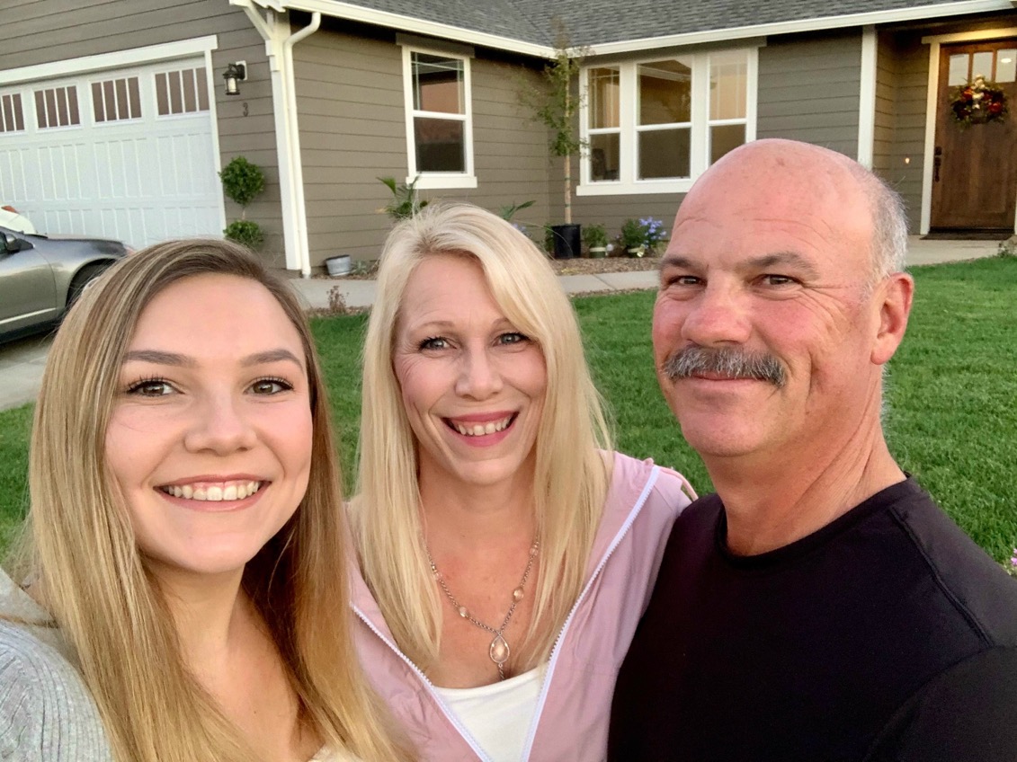 Kelsea Kennedy poses with her mom and dad in front of their new house.