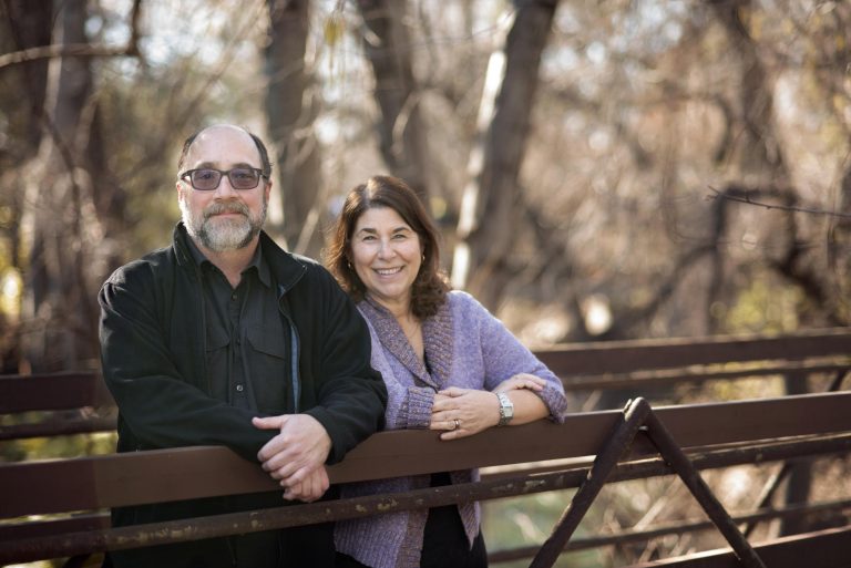 Campus couples Diana Dwyer (left) and Joe Picard (right) smile on a bridge by the creek on Monday, January 30, 2017 in Chico, Calif. (Jessica Bartlett/Student Photographer)