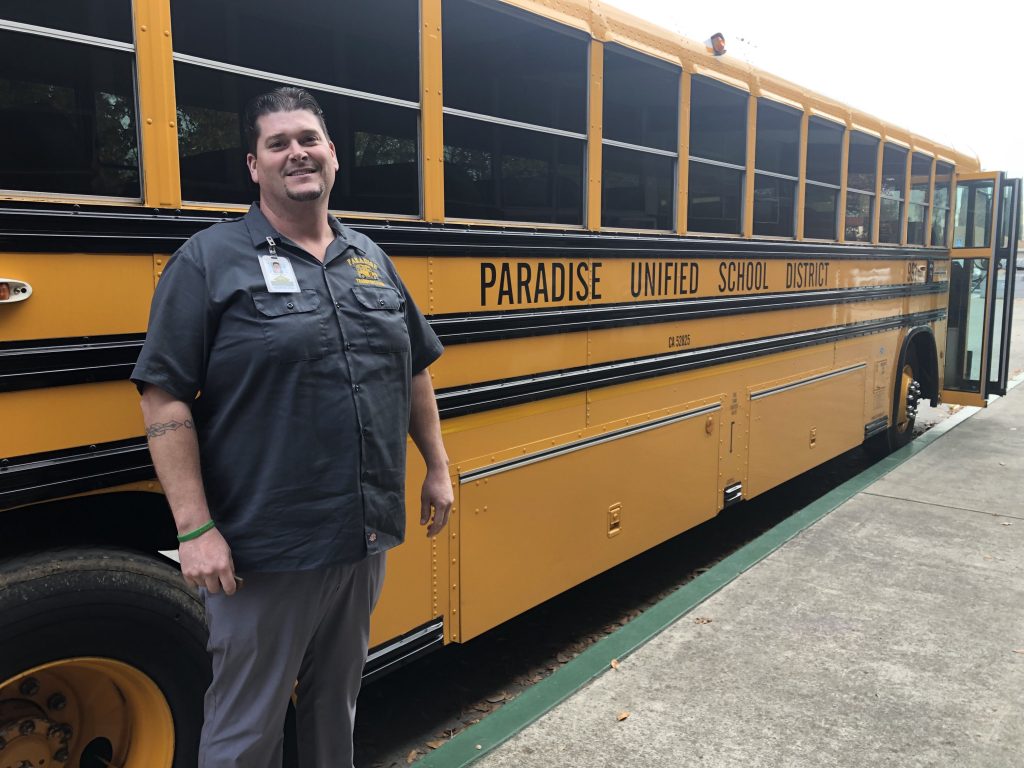 Kevin McKay standing in front of the Paradise Unified School District school bus.
