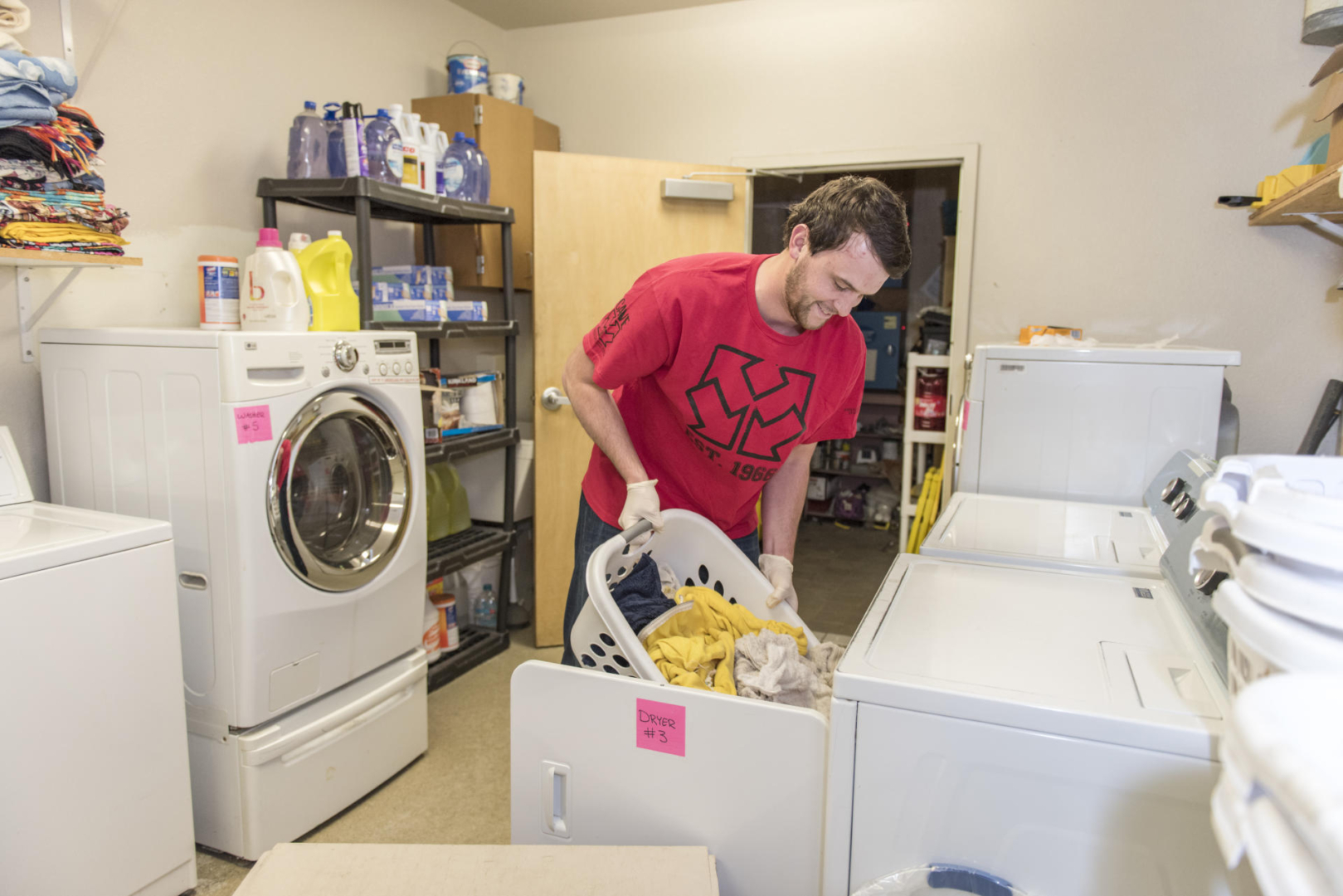A student does laundry at a shelter serving individuals experiencing homelessness.
