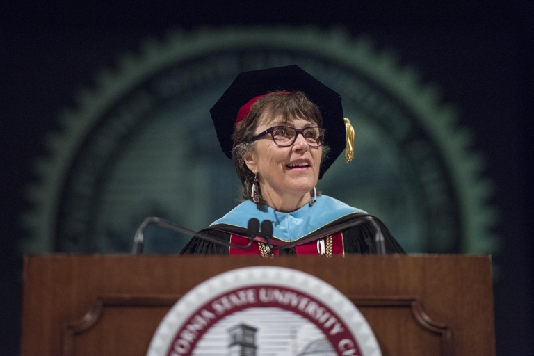 Chico State President Gayle Hutchinson speaks from a podium during a graduate student ceremony.