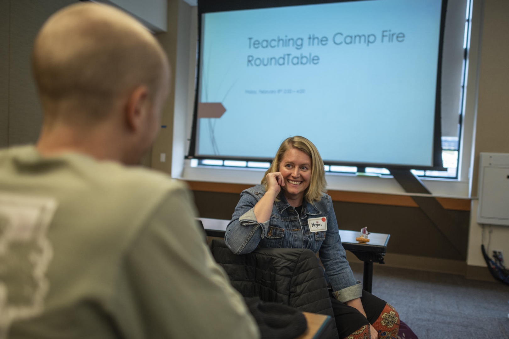 As she waits to speak in front of educators about teaching the Camp Fire on campus, she smiles and shares a lighthearted moment with a colleague.