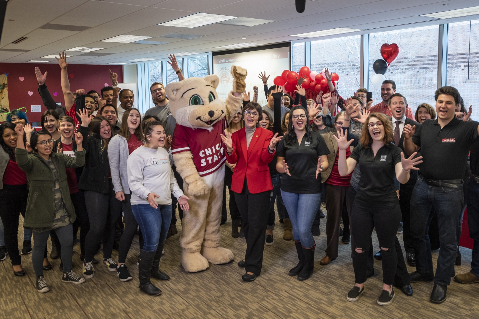 President Gayle Hutchinson and Willie the Wildcat, the mascot, cheer with dozens of students to celebrate Giving Day.