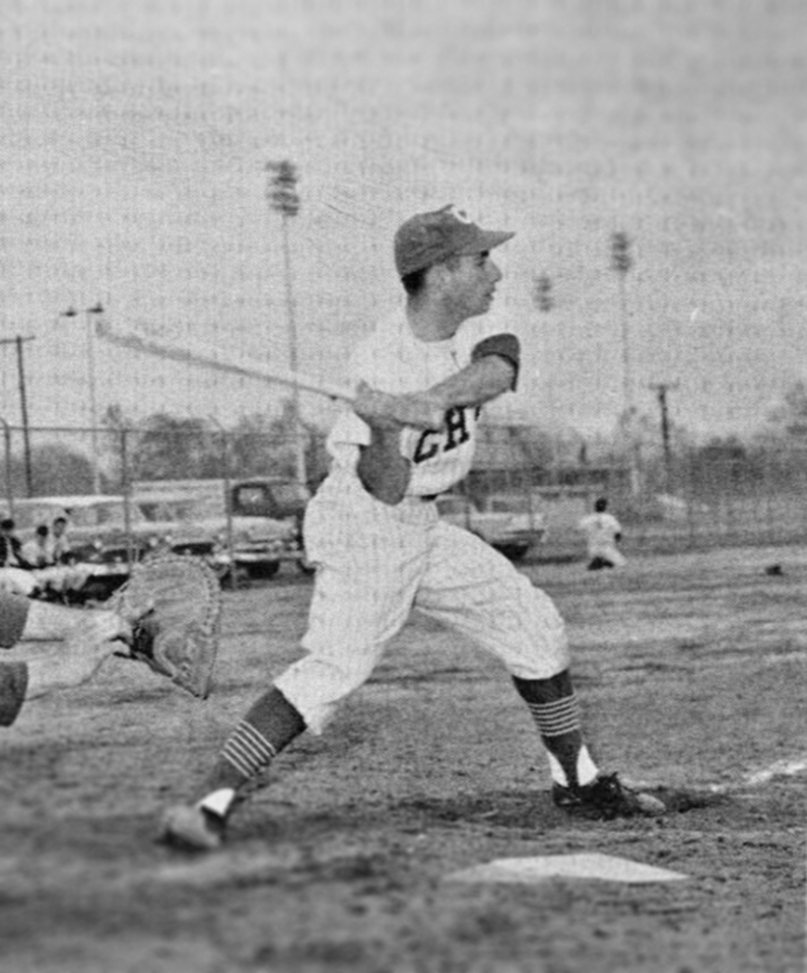A black and white photo shows a Chico State player swinging at a pitch at home plate decades ago.