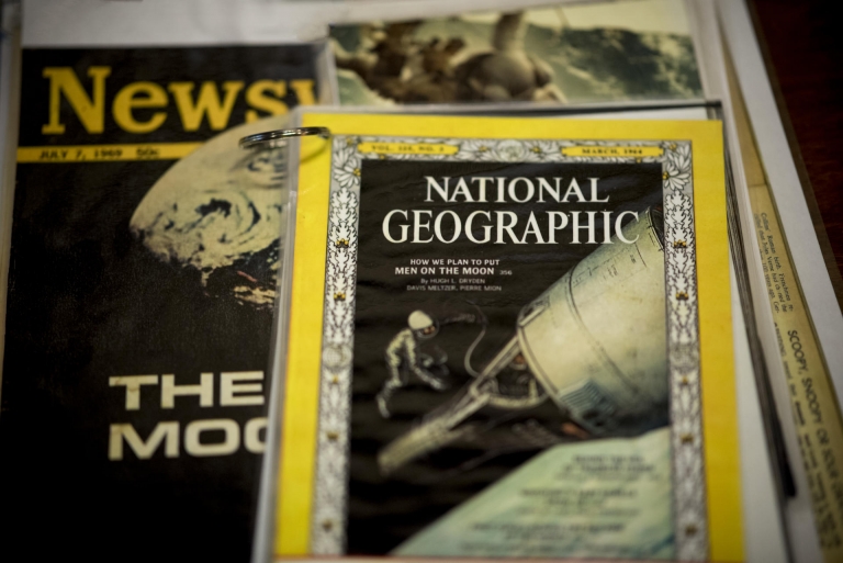 A stack of national publications report the significance of the Apollo 11 mission to the moon in 1969.