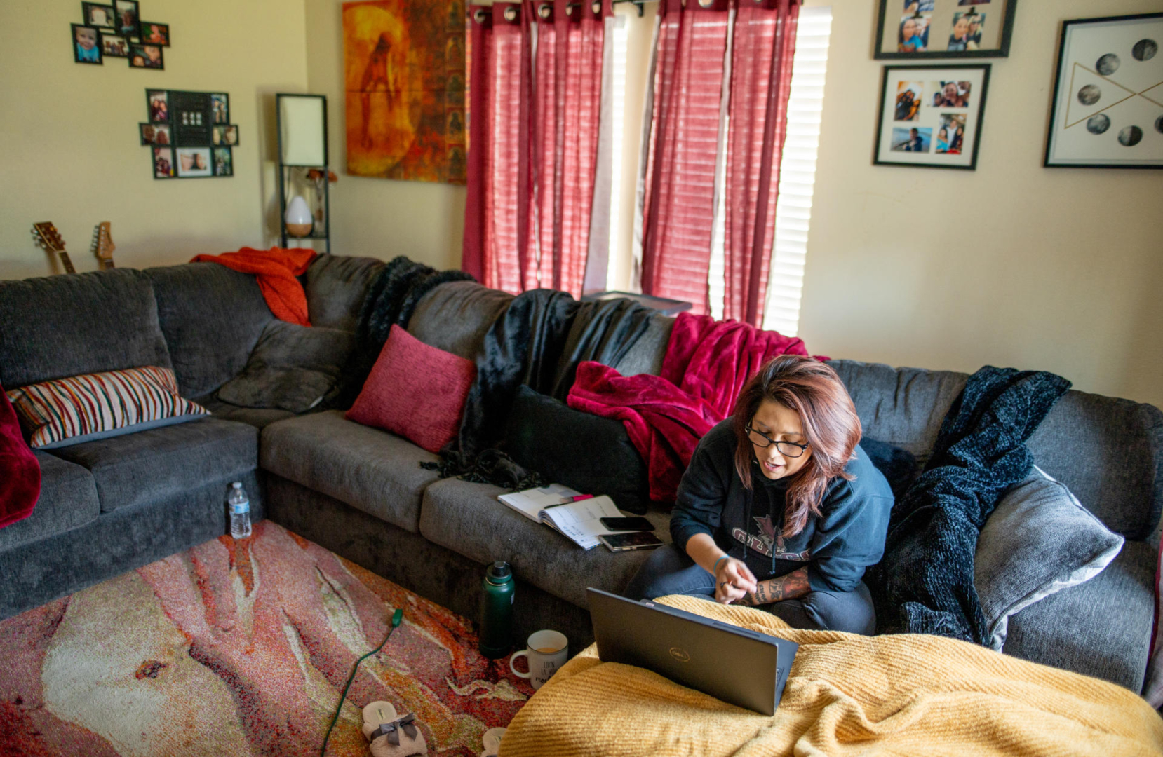 Irene Echavarria sits on her couch as she talks to fellow students via her laptop during a class.