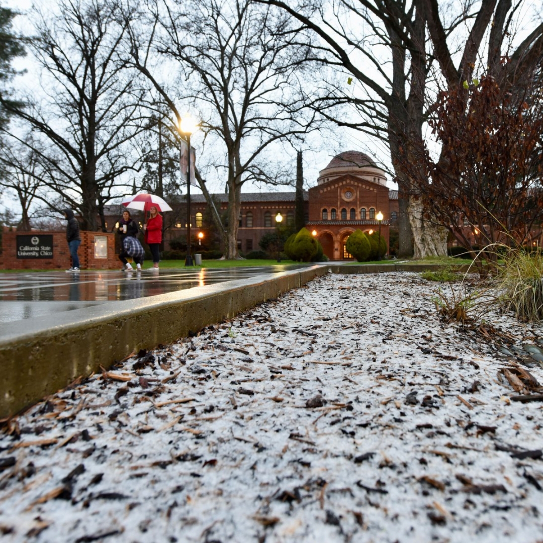 A heavy layer of hail gives the appearance of a snowy scene in front of the Kendall Hall walkway