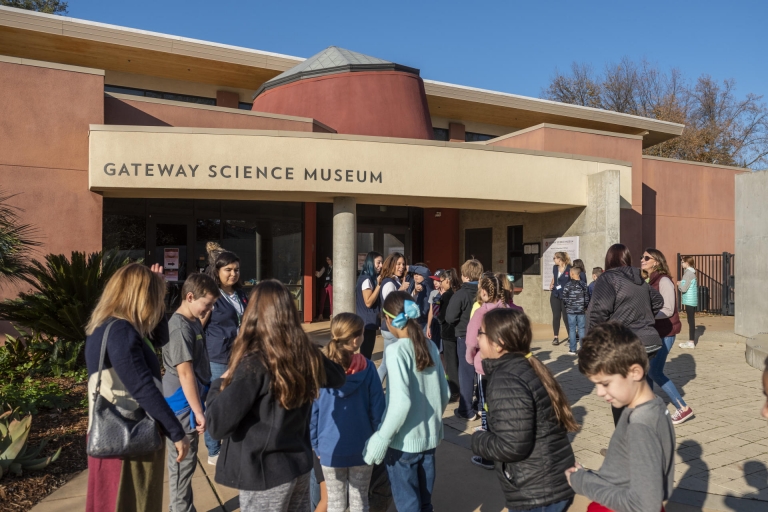 Elementary school students and teachers eagerly await the opening of the Gateway Science Museum for their field trip.