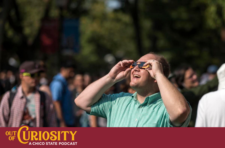 Nick Nelson smiles as he wears protective glasses and looks at a solar eclipse among a large crowd at Chico State.