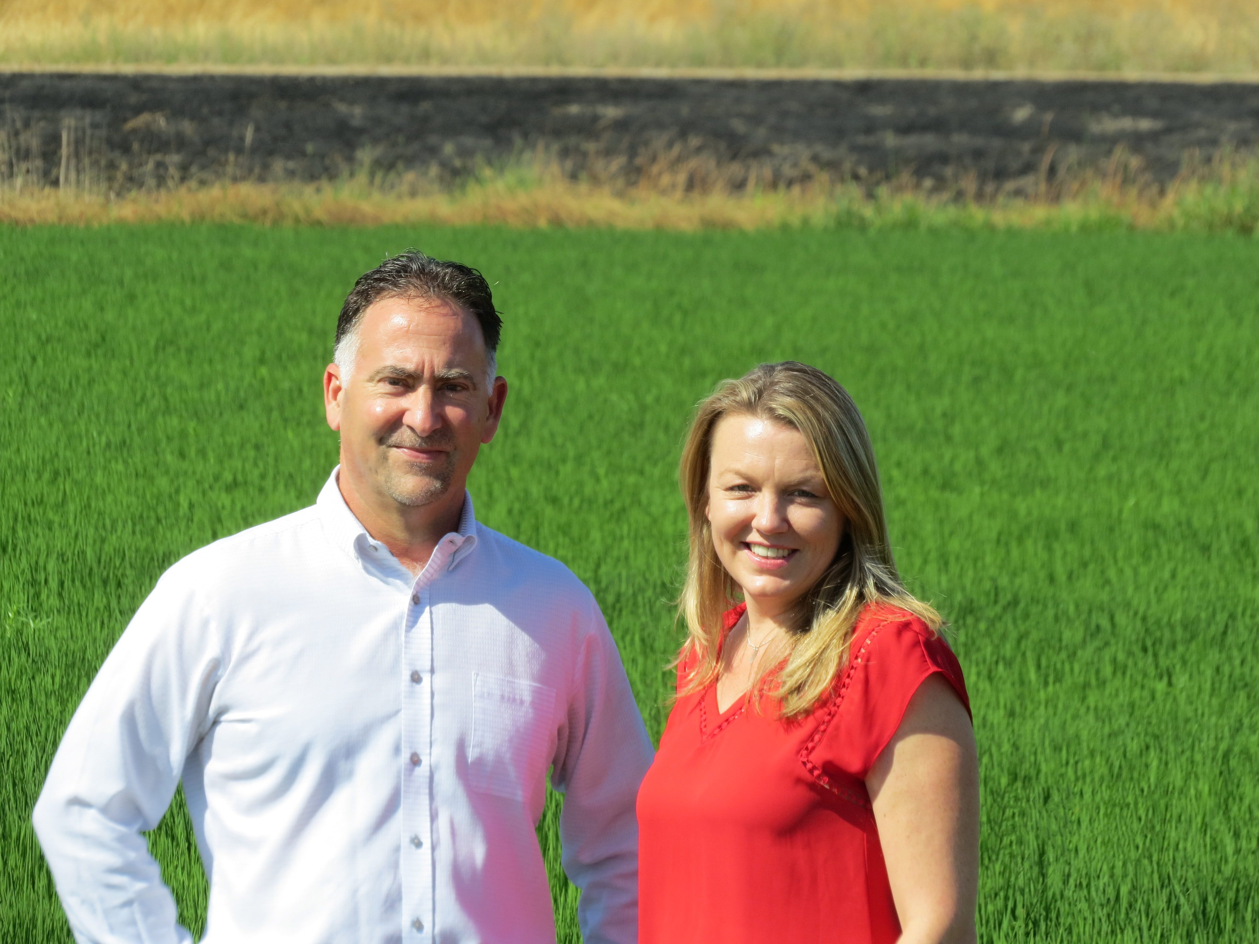 Erin O'Donnell and Steve Vargas stand in a rice field.