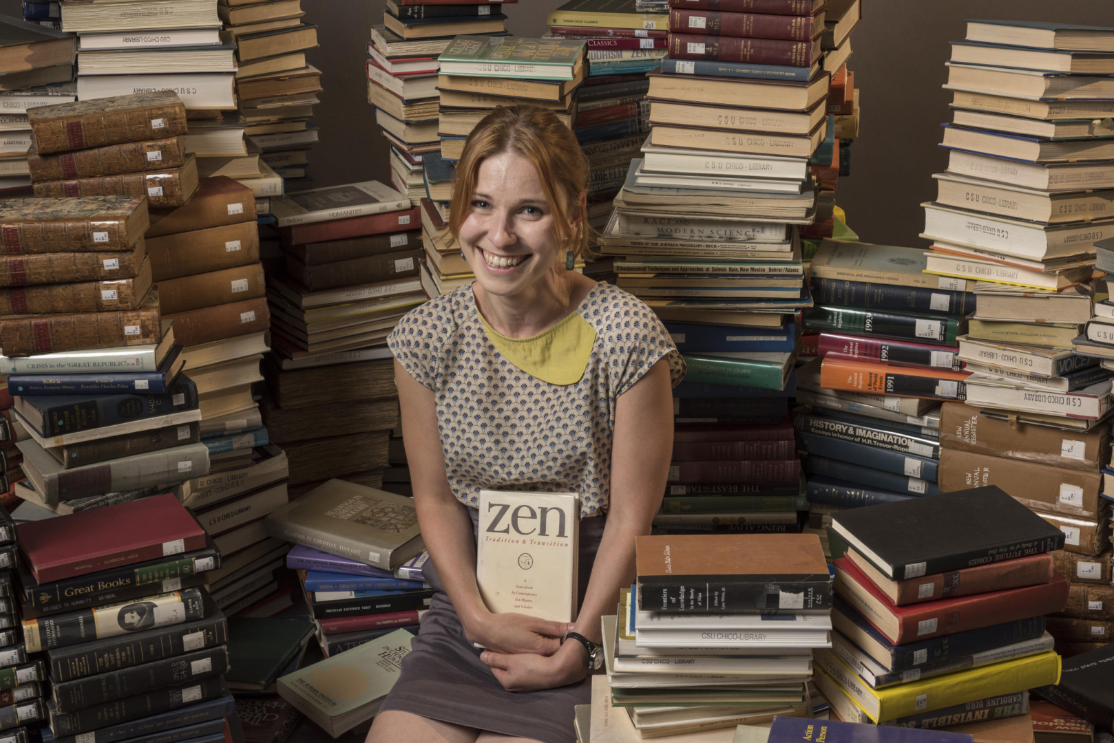 Friederike Fichtner sits amid piles of books.