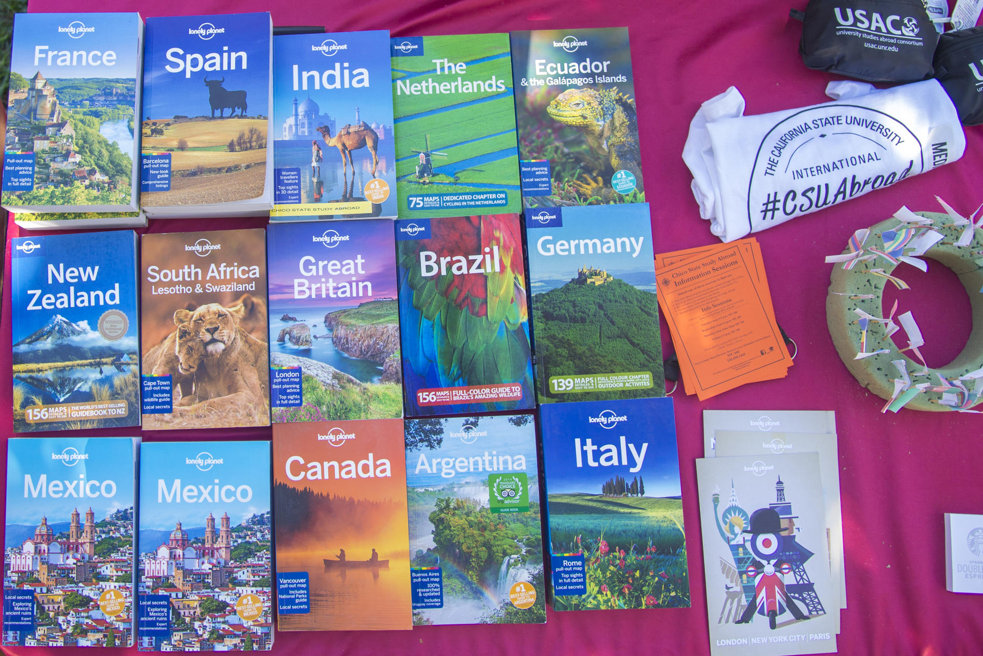 Books highlighting different countries around the world are on a table.