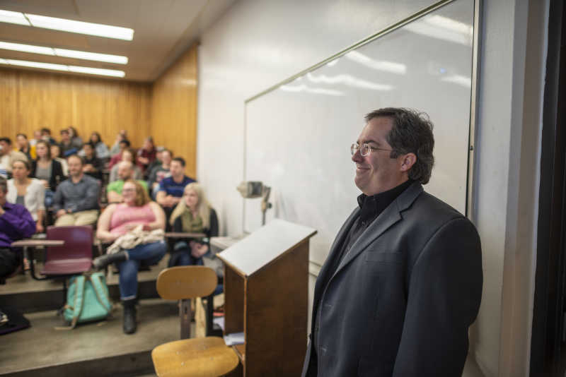 Sam Clegg smiles as he prepares to talk to a group of Chico State students inside a classroom.