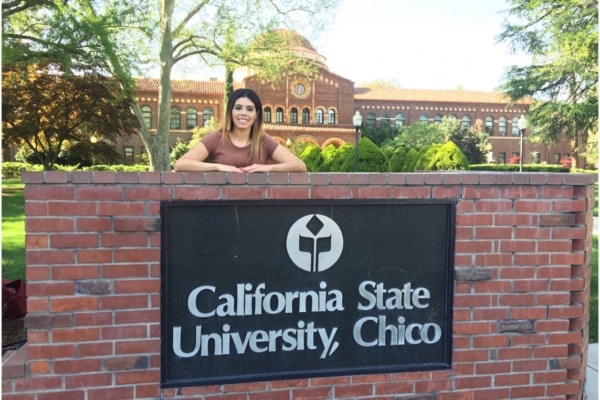 Veronica Ledesma poses standing behind a Chico State sign made of bricks