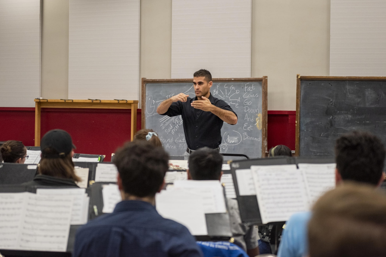 Chris Navarrete conducts a rehearsal in front of seated students