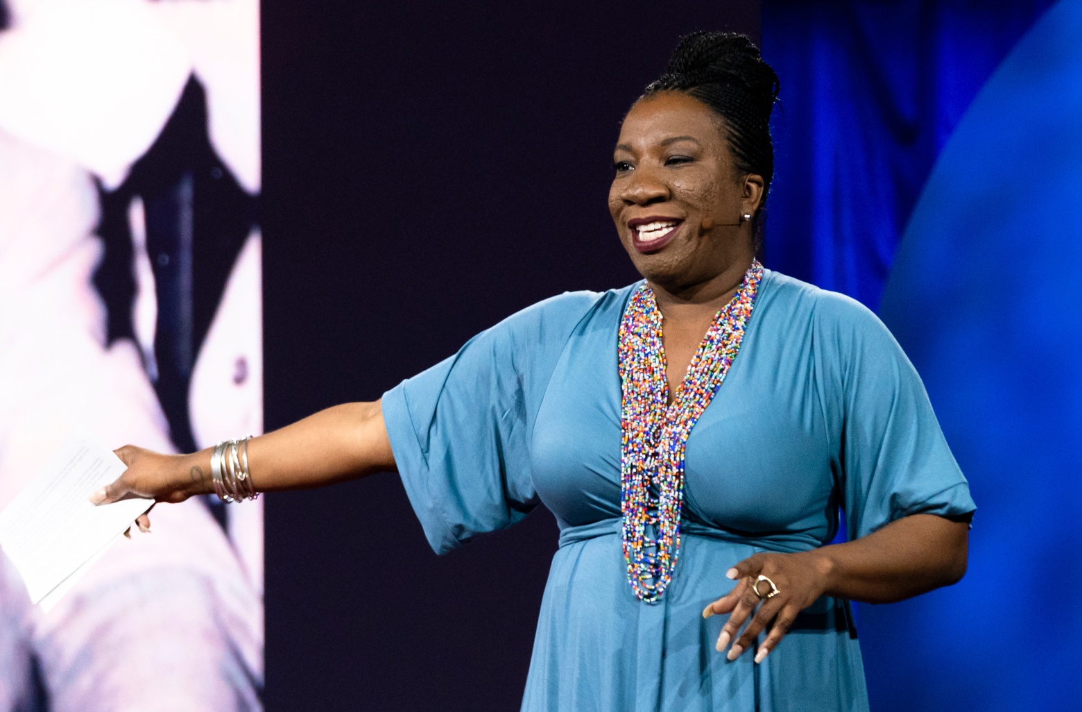 Tarana Burke gestures with one arm while speaking on a stage.