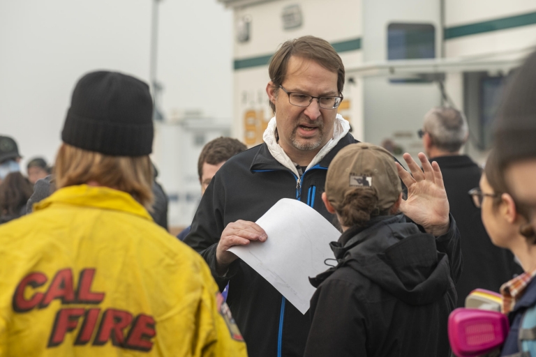 Eric Bartlink speaks to a colleague under smoke-filled skies at the command center for Camp Fire response.