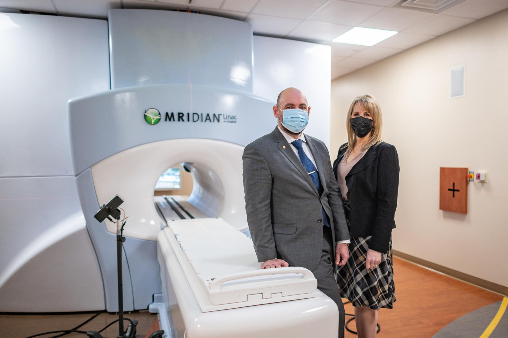 Two people pose in a room with an MRI machine.
