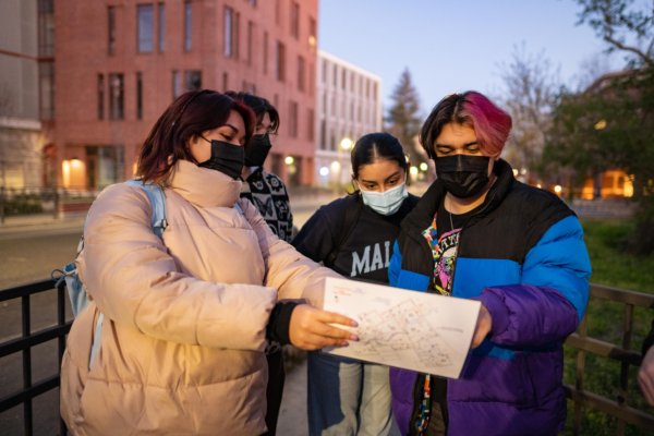 Masked students look at a map of campus while marking safety concerns they found.