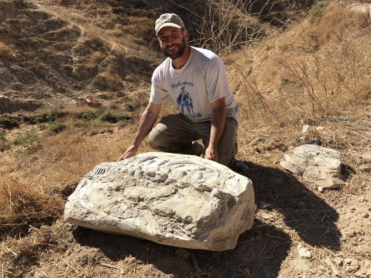 Russell Shapiro poses with the found 15-million-year-old whale vertebrae fossil in Simi Valley.