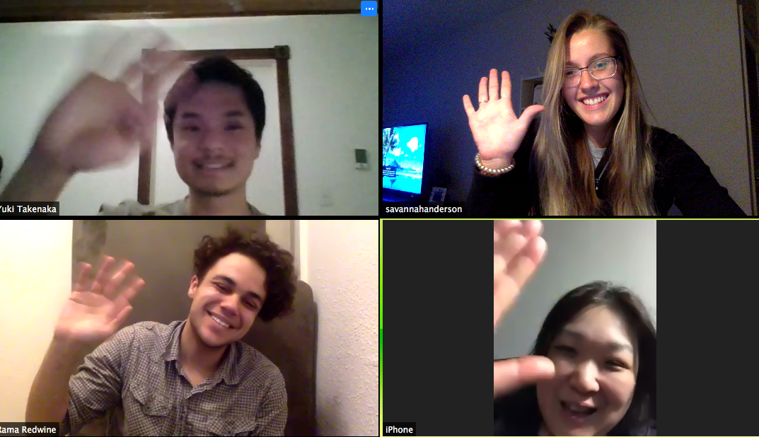 Four people wave at one another while each on their own screen on Zoom.