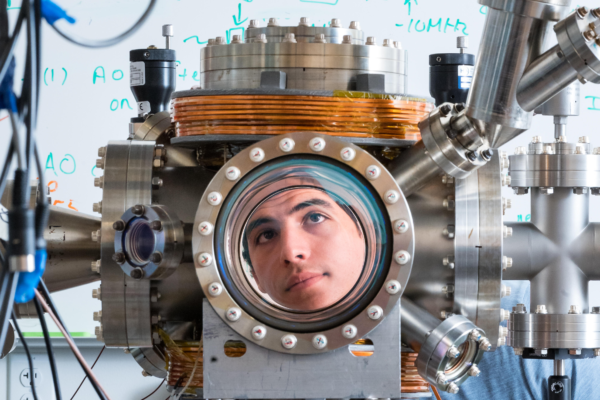 Nicholas Esparza looks through the high vacuum chamber in the ultracold lab.