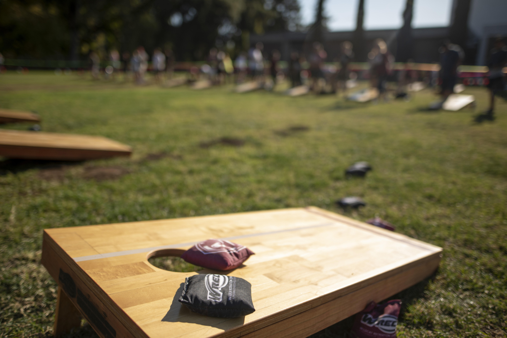 WREC-branded bean bags lay on a corn hole board in the sun. 