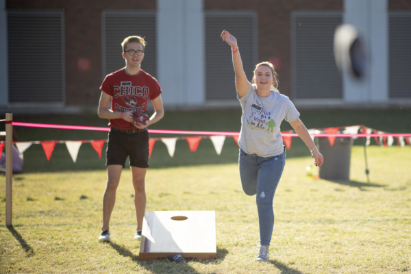 Students throw bean bags as part of a cornhole tournament.