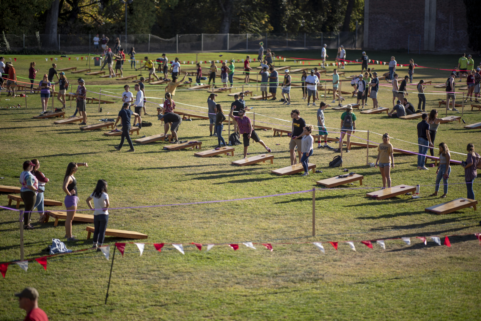 A distanced view show dozens of teams playing corn hole on the Yolo Hall field.
