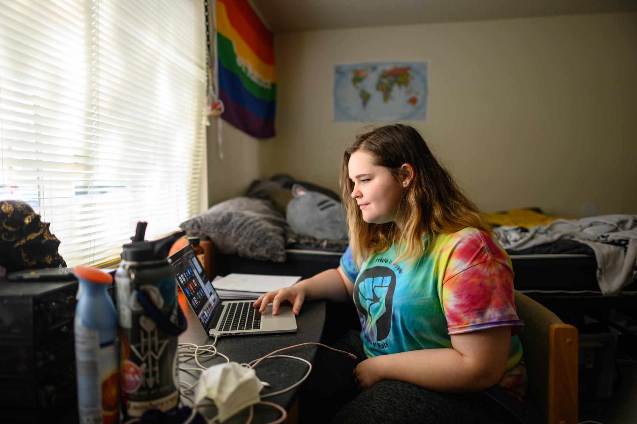 A student works at her computer in her room.
