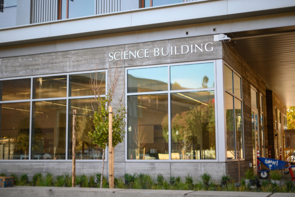 The exterior of the science building includes large windows and native plant landscaping.