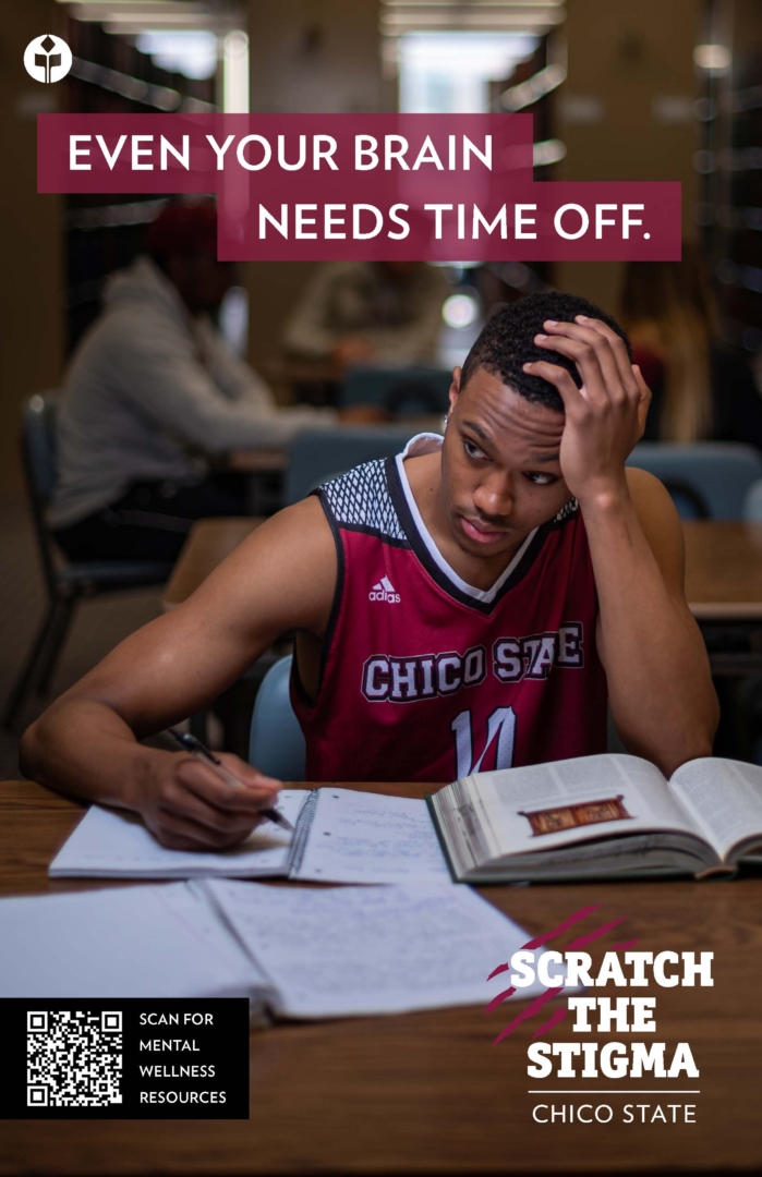 A basketball player sits with his head on his head as he works in a notebook in the library. 