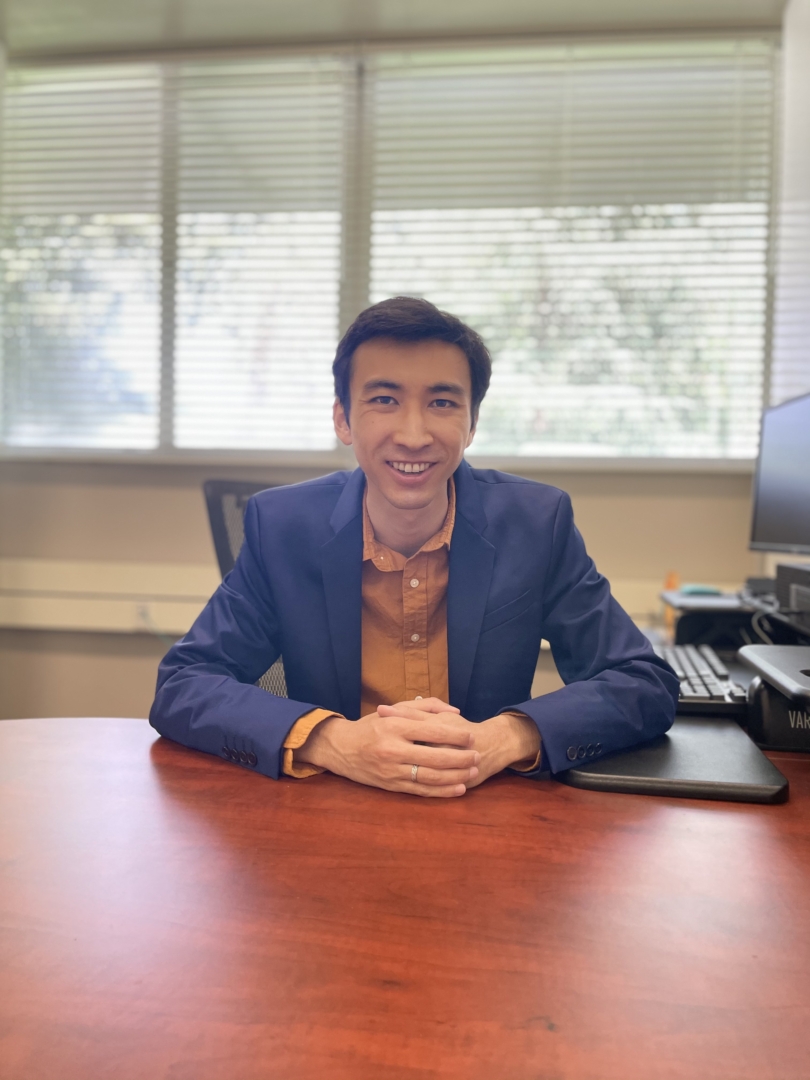 Alex Wong sits at his desk in his office.