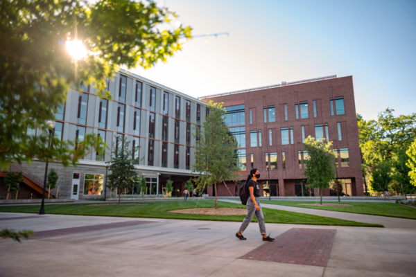 A student walks past the Science Building in the evening light.