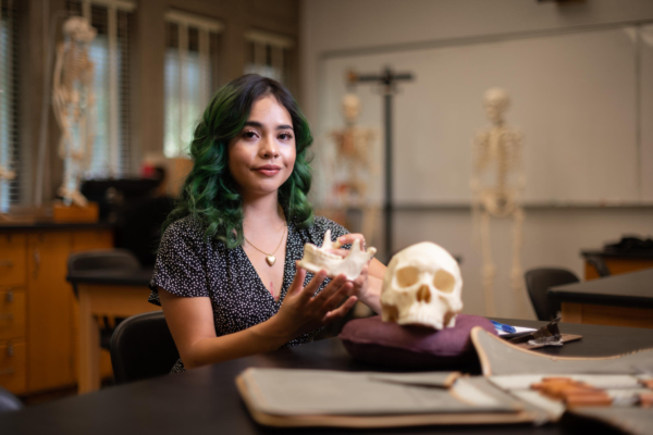 Daisy Linsangan holds pieces of skull models in her hands in the anthropology lab.