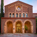 The brick facade of an academic building with three arches in the front