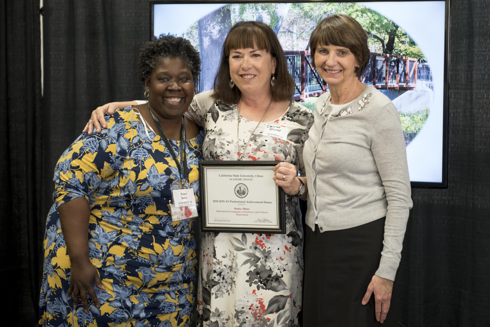 Dean of Humanities and Fine Arts Tracy Butts (left) and Provost Debra Larson (right) present Denise Minor (center) with Professional Achievement Honors at Inspired '19. 