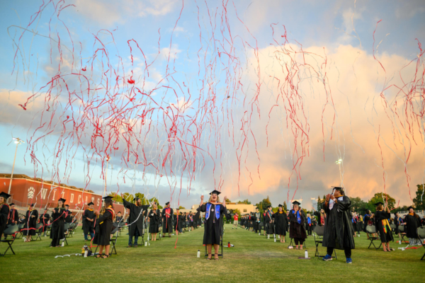 Streamers fall to the ground as masters graduates celebrate their Commencement.