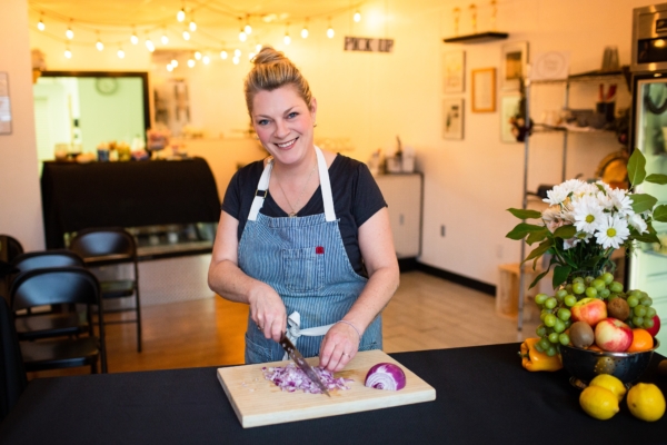 Debra Sims preps food in a kitchen.