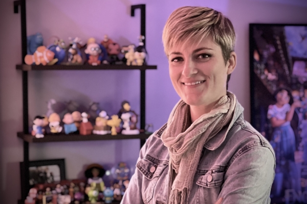 Theresa Adolph stands in front of shelves of Disney Characters