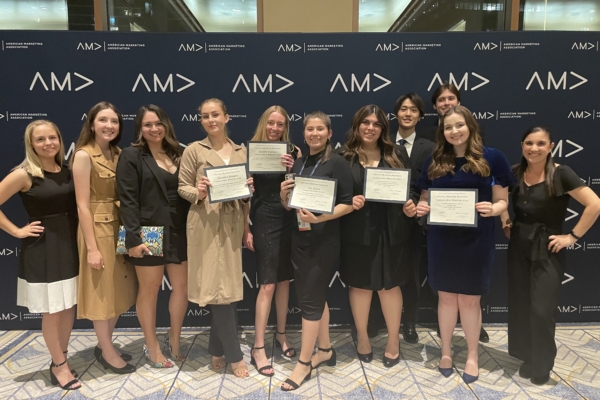 Students stand with their award certificates at the international AMA competition.