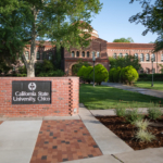 A sign reading California State University, Chico sits in front of a brick academic building