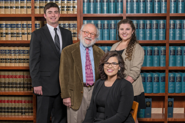 Ed Bronson stands with a group of legal students in the CLIC law library.