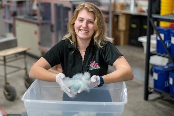 Aubrey Miller holds a handful of tootbrush fibers in her hand in the concrete lab.