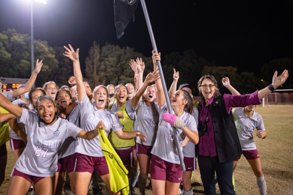 President Hutchinson celebrates on the field with the women's soccer team.
