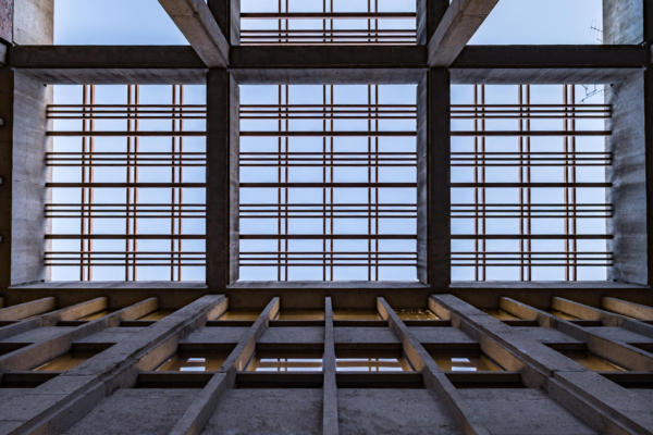 A photo from the ground looking up at intersecting bars beneath a library.